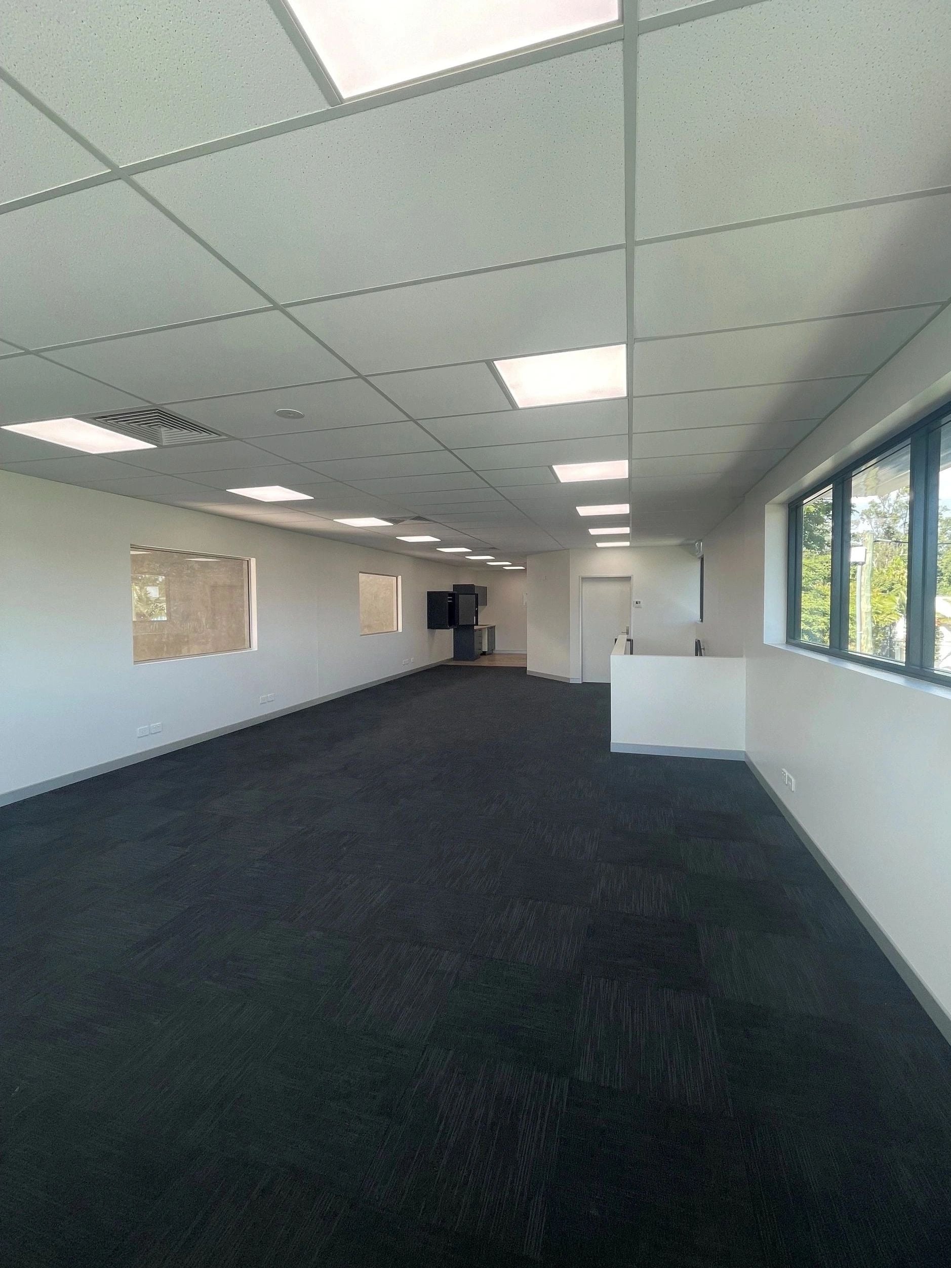 Open-plan office fit out with an exposed grid suspended ceiling and recessed LED panels